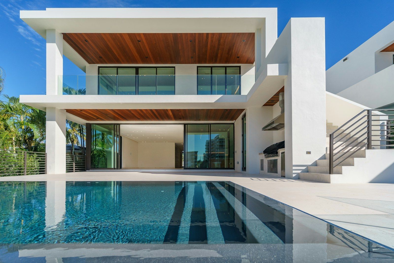 Casa branca com piscina, beiral em madeira e varanda integrada (imagem ilustrativa)